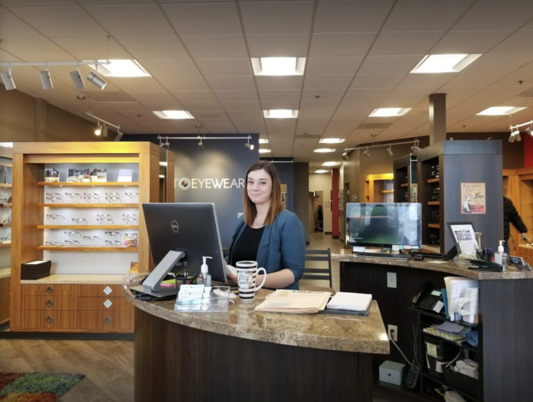 The front desk receptionist smiles from behind the counter at Accent Eyewear in Oregon